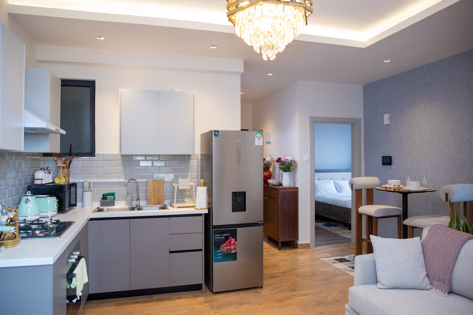 Full open-plan view of kitchen, dining and bedroom door