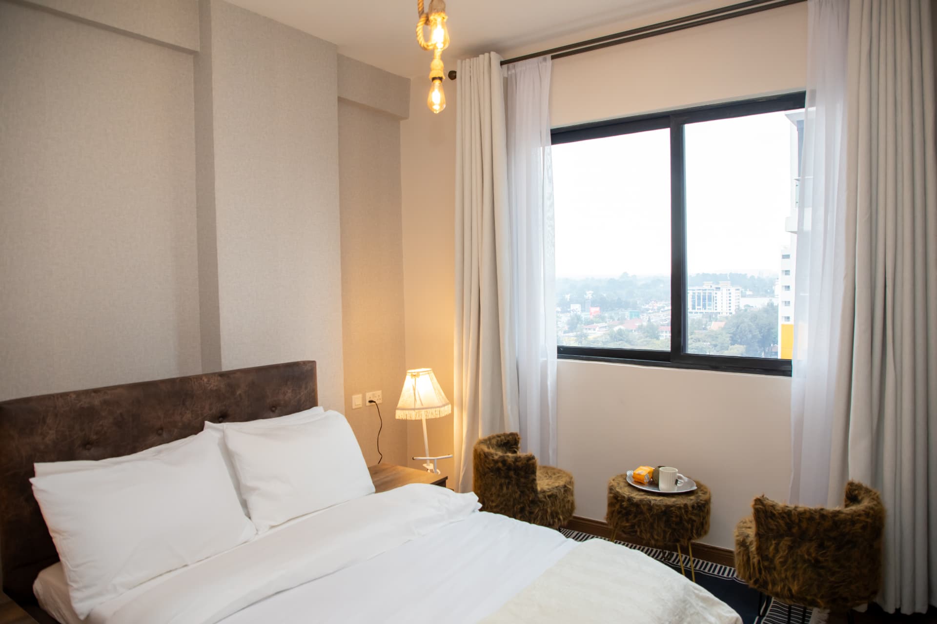 Bedroom with leather headboard and a window seating nook
