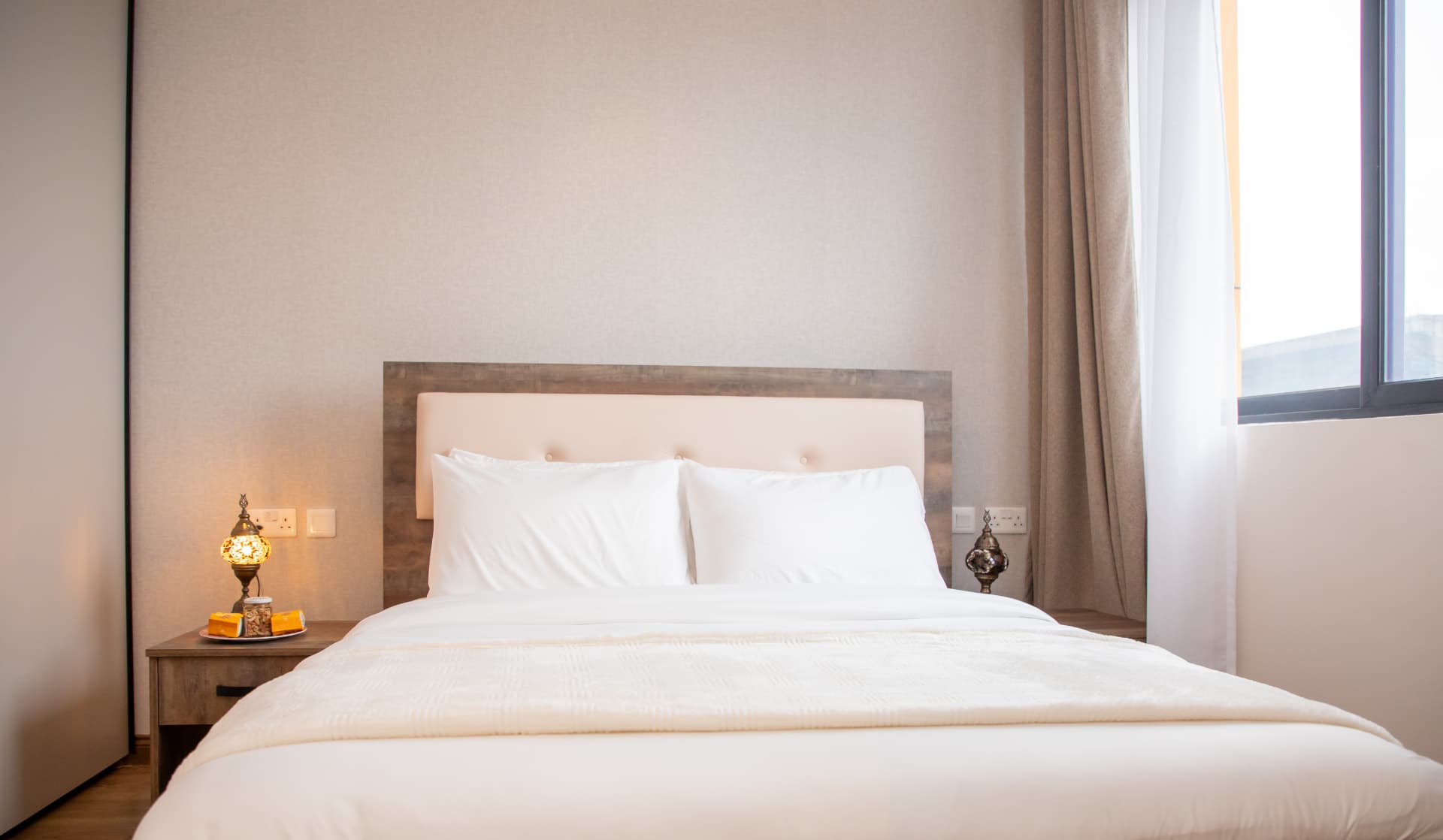 Bed with upholstered headboard and mosaic bedside lamp