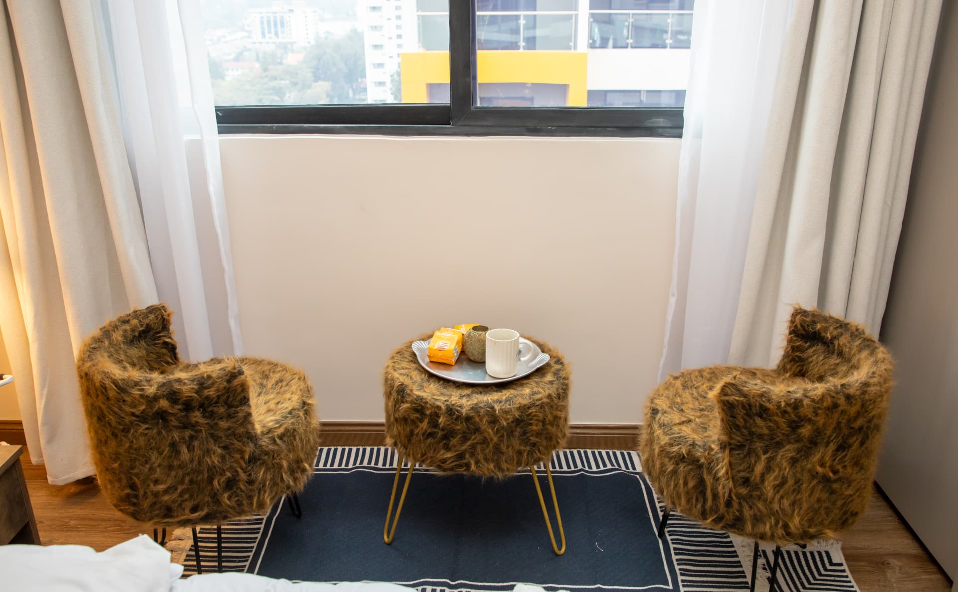 Window nook with fur stools, tray and a high-floor view