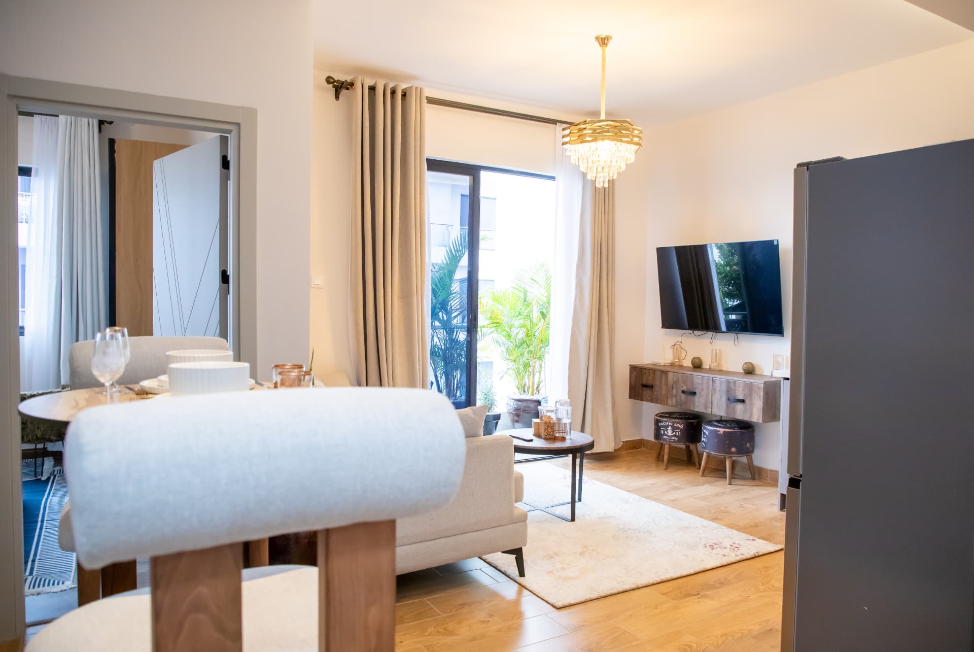 Living room with balcony doors, curtains and TV wall