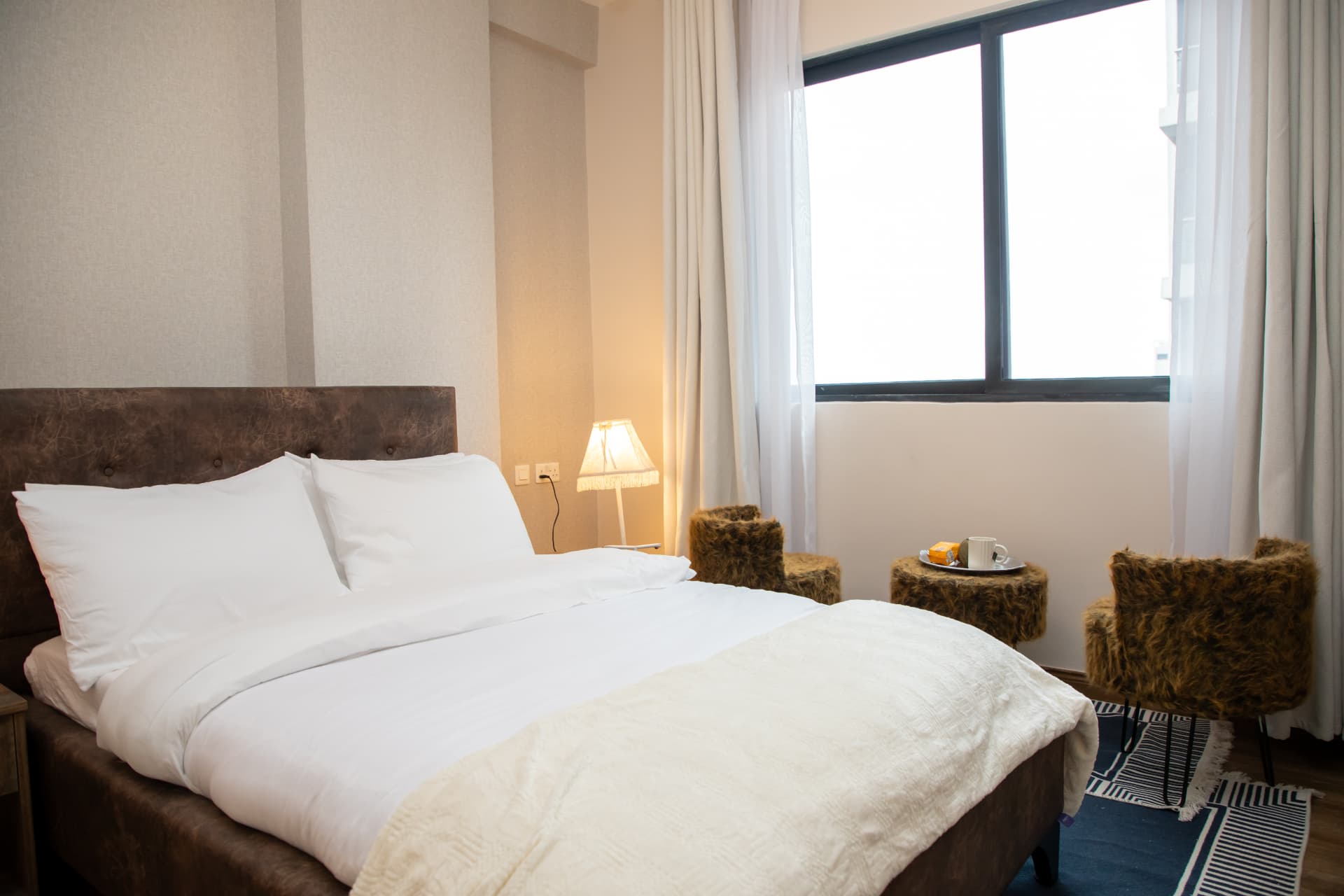 Wide view of the bedroom with window stools and city view