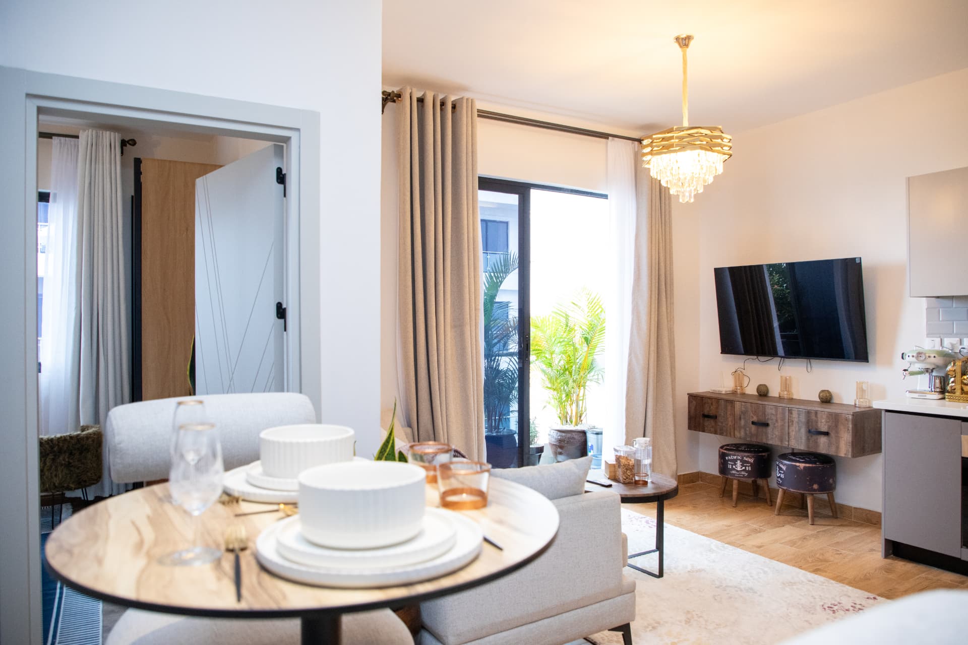 Dining table laid for two with the living room and balcony beyond
