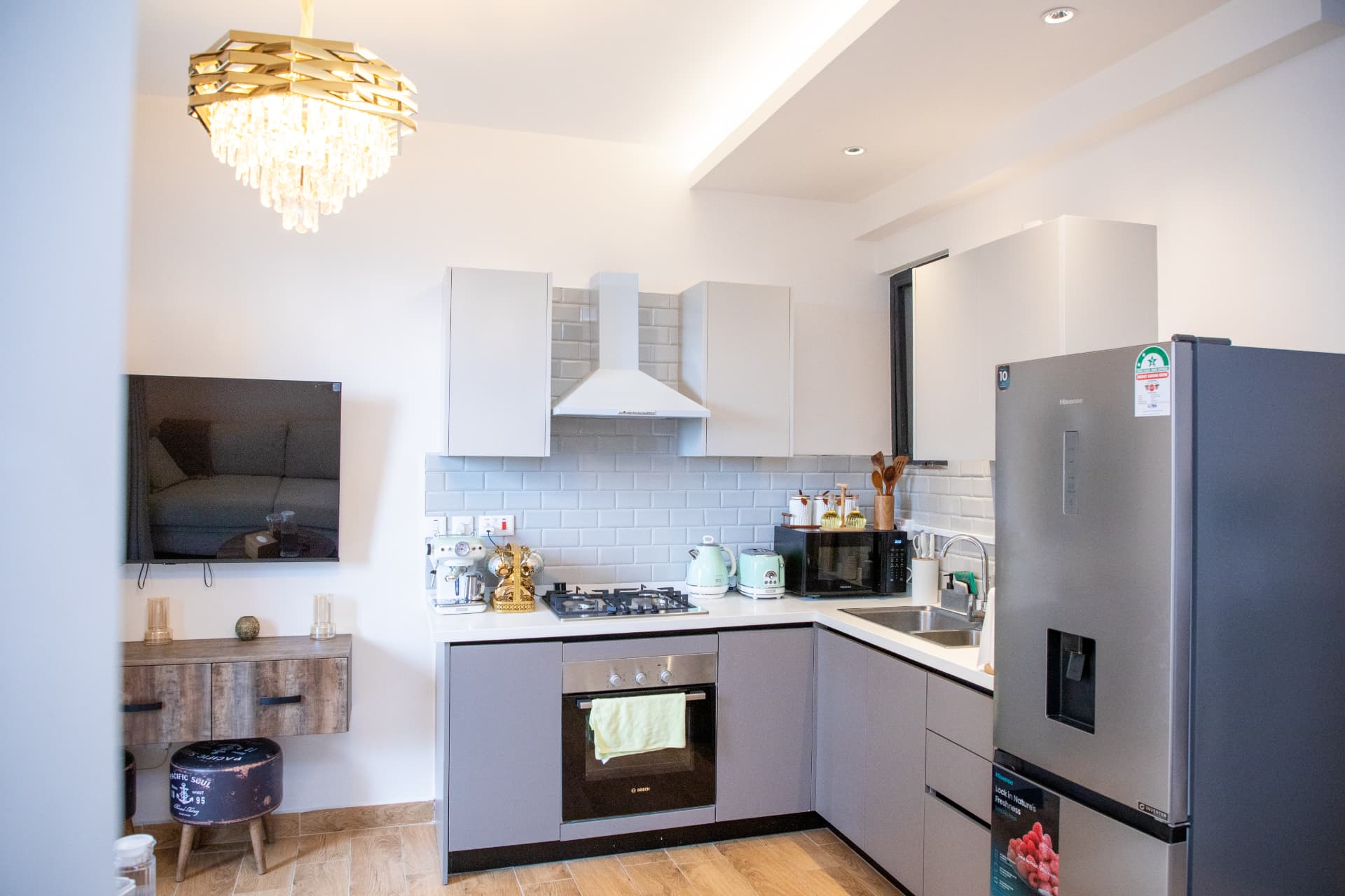 Kitchen with tiled splashback and TV on the living room wall