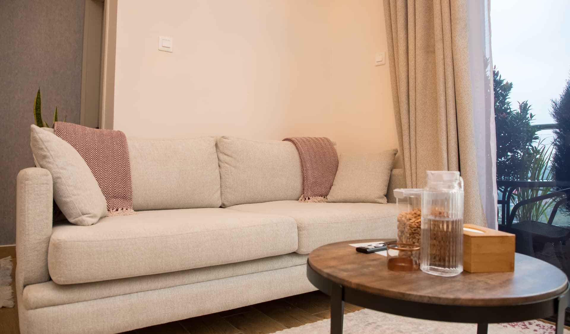 Linen sofa with cushions beside the balcony window