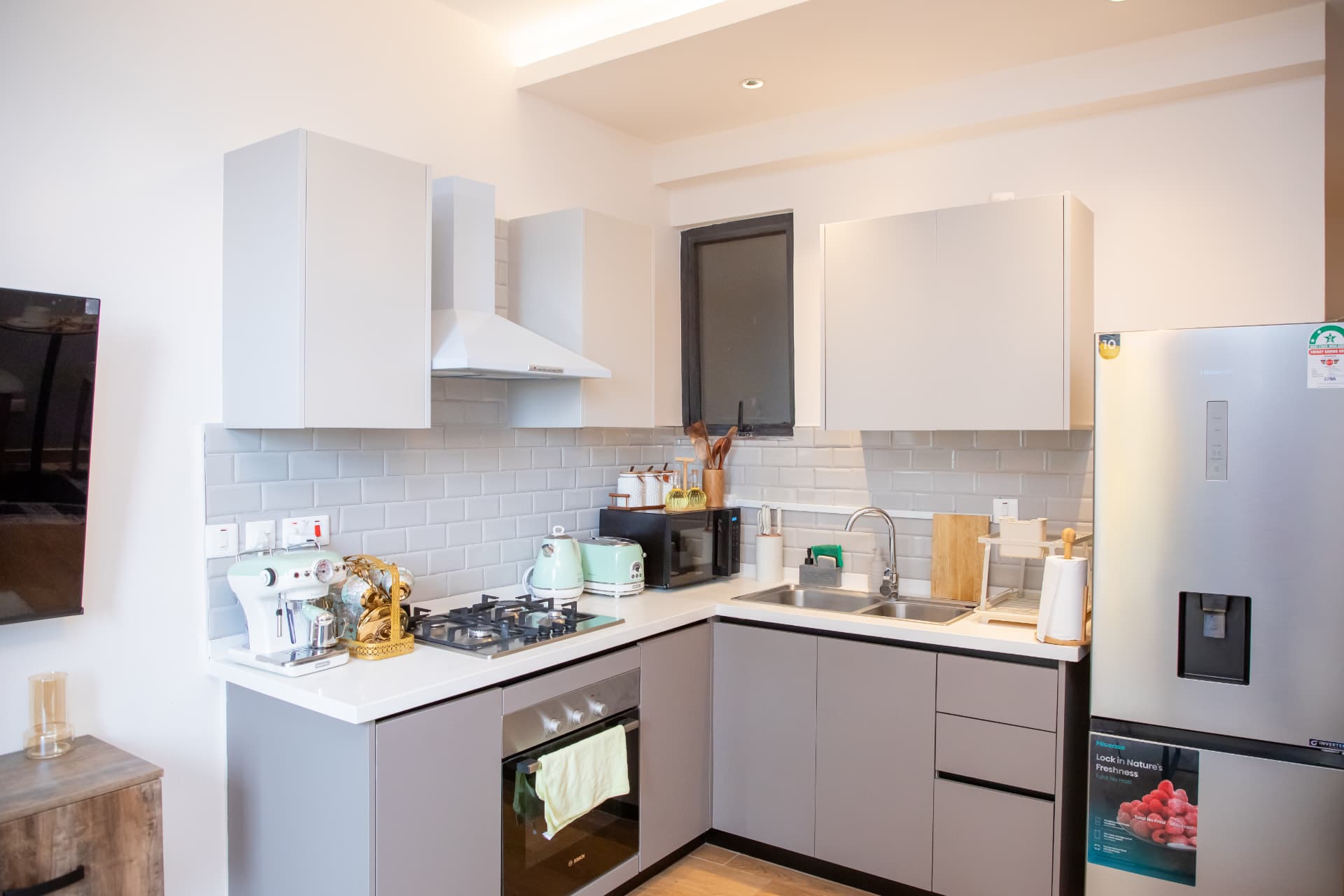 Grey kitchen with gas hob, oven and full-height fridge