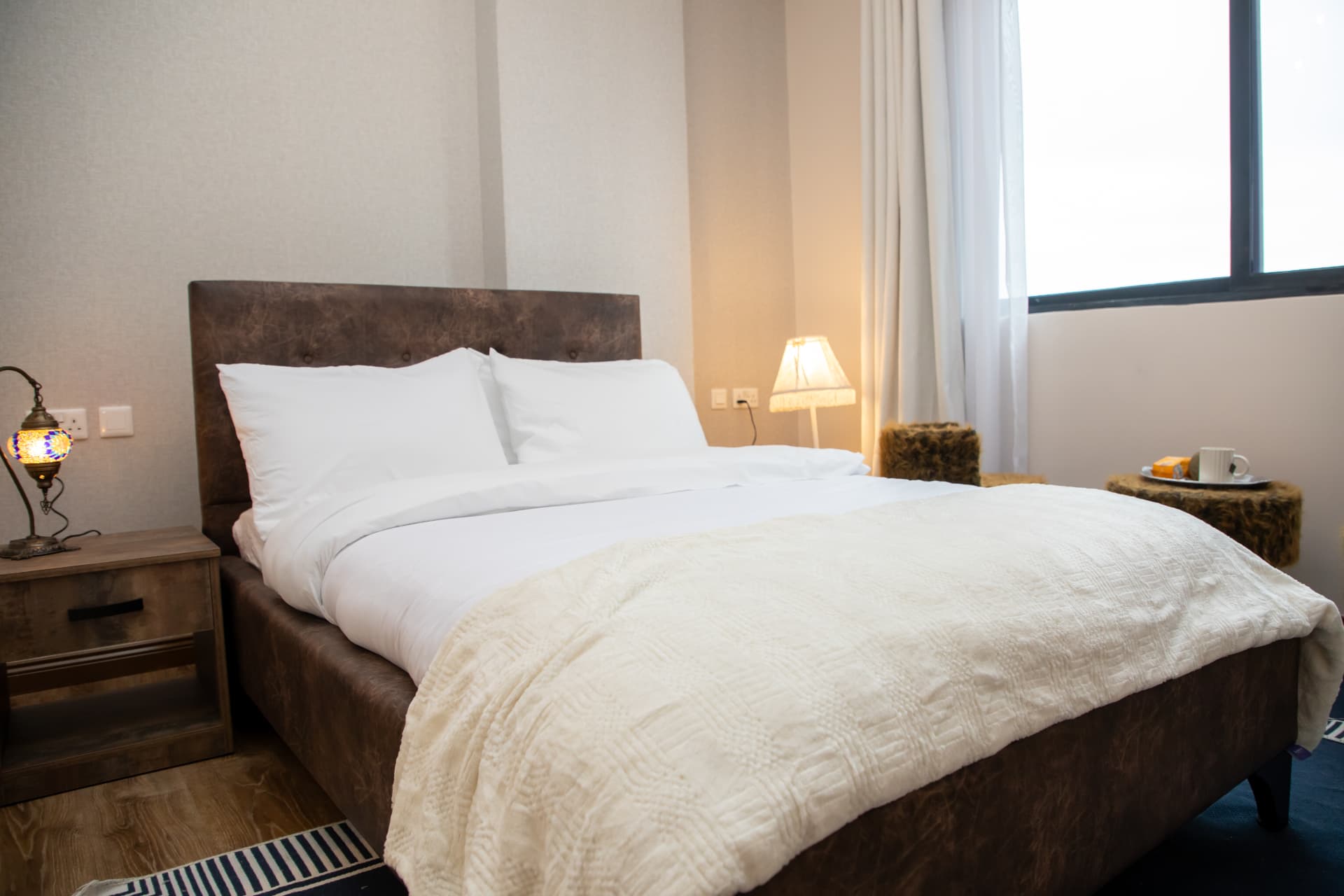 Low view of the bed with a textured throw at its foot
