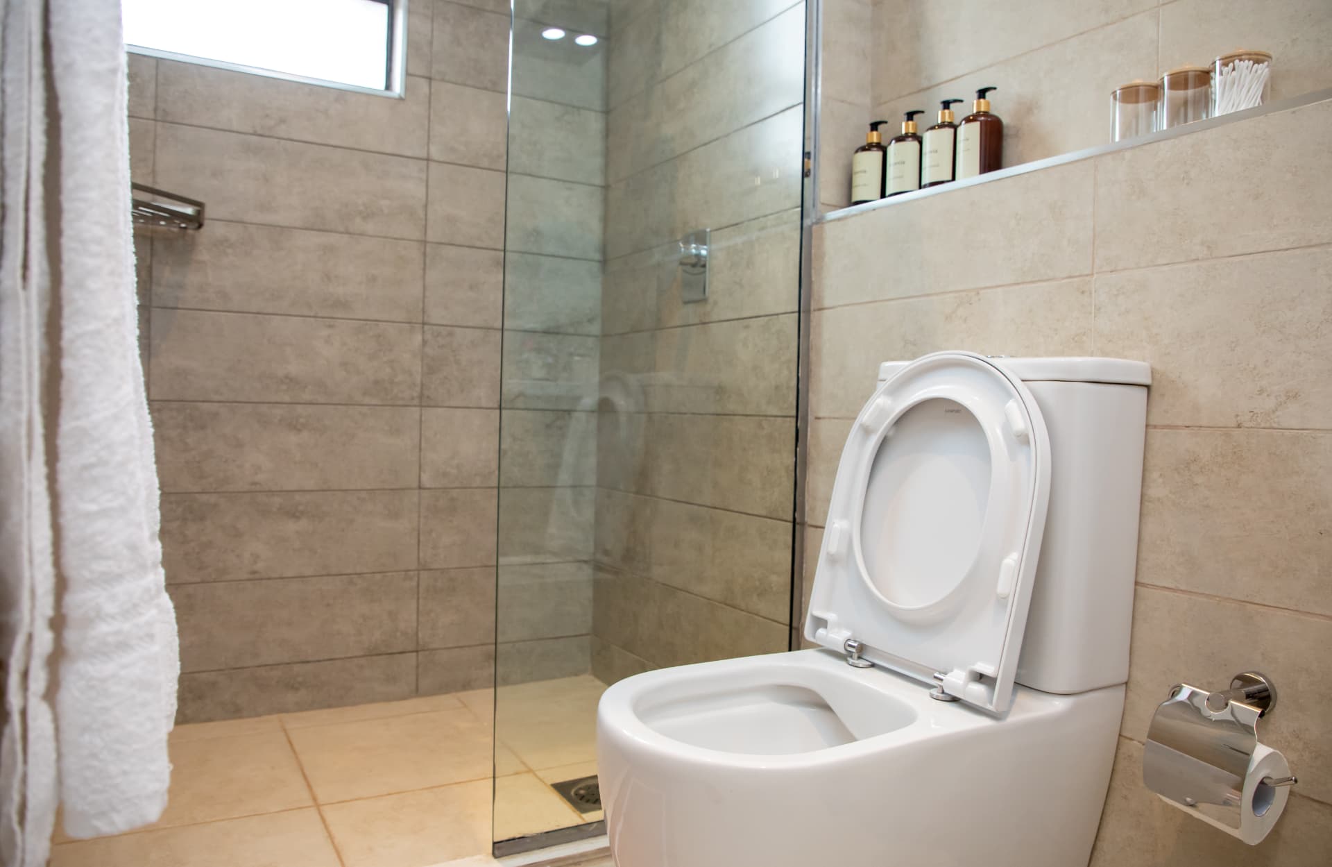 Walk-in glass shower with towels and toiletries